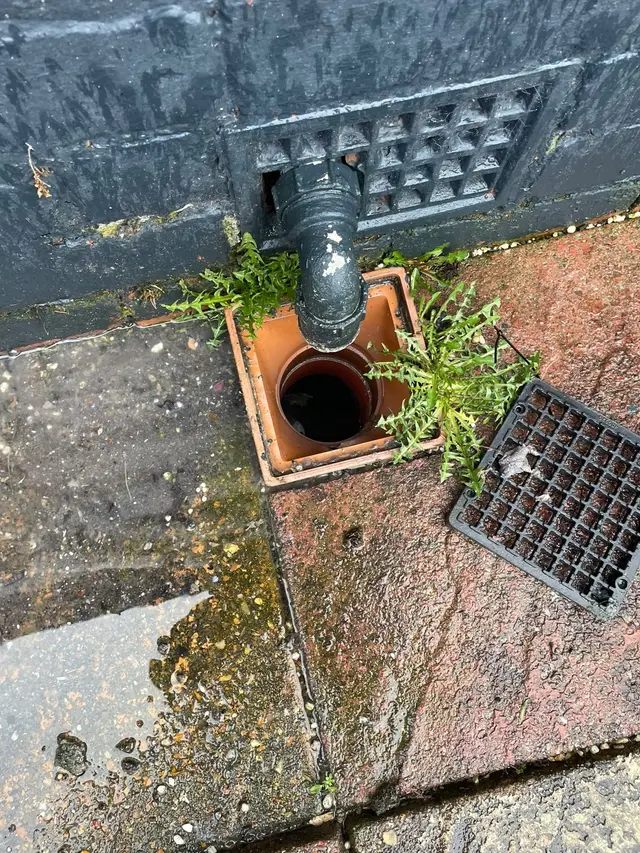 The same gully cleared, with the drain opening visible